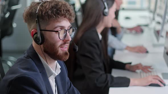 Close Up Portrait Man of a Technical Customer Support Specialist Talking on a Headset While Working