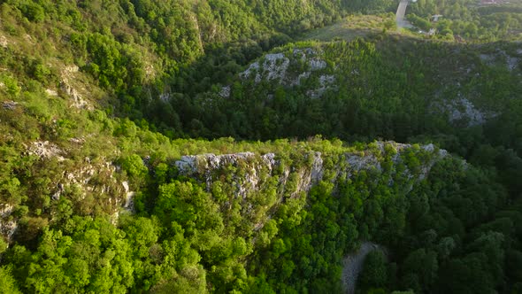 Aerial view of karst landscape, with valleys and cliffs, at sunset