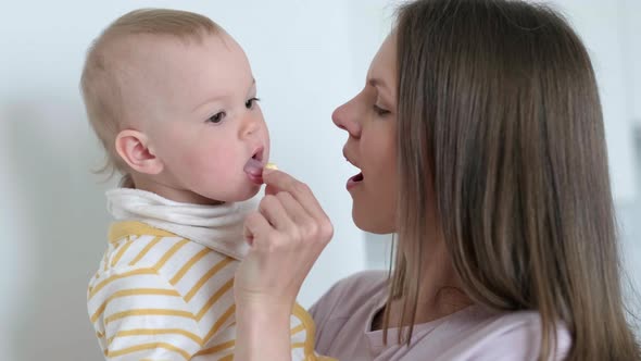 Mom Puts Vitamin in the Childs Mouth