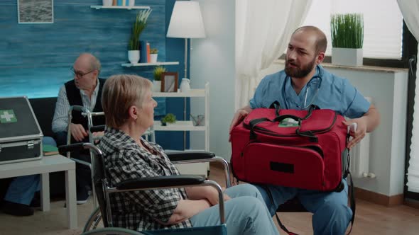 Medical Assistant Using Thermometer on Invalid Old Woman