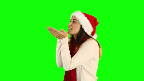 Woman in santa hat and warm clothing blowing over hands