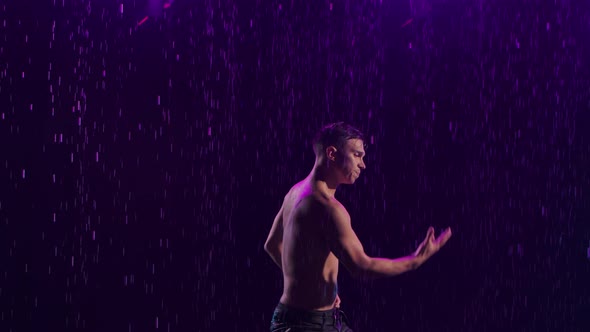 Contemporary Ballet Man Performs Elements of Modern Choreography Standing on Surface Water in Rain