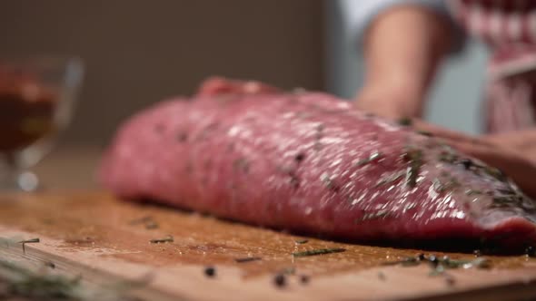 The Chef Woman Pours Oil and Spices to the Beef