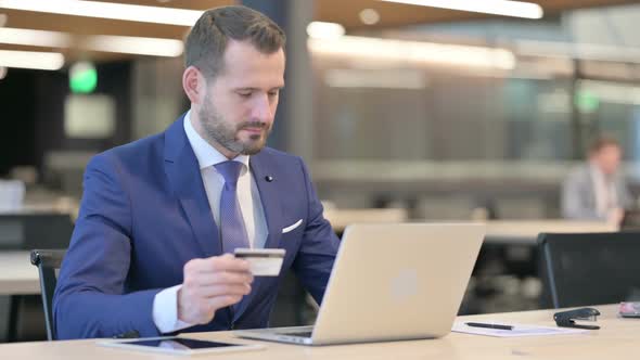 Successful Online Payment on Laptop By Middle Aged Businessman