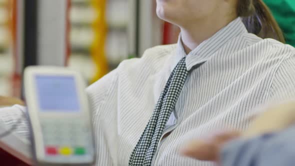 Young Woman Working at register in Supermarket