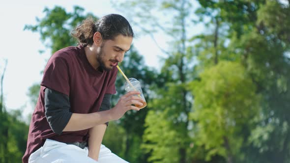 Closeup Portrait of Handsome Arab Man Sitting in the Park and Drinking Coffee Tonic
