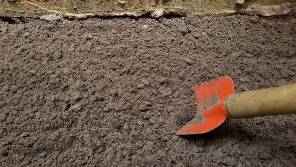 Close up on steel trowel to dig into bare soil garden