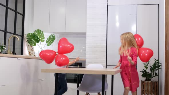 Children Running Around the Table with Red Heart Shape Balloons at Home