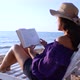 A Girl in a Straw Hat Sits on a White Sun Lounger By the Sea with a Book in Her Hands - VideoHive Item for Sale