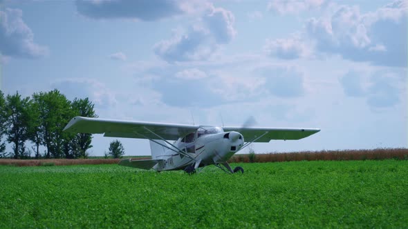 Ultralight Private Airplane Preparing to Taking Off on Green Airfield Summer Day