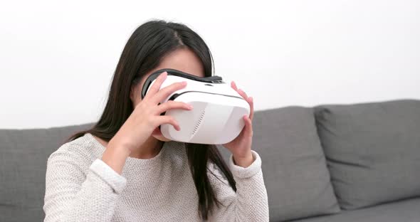 Woman looking though VR device at home