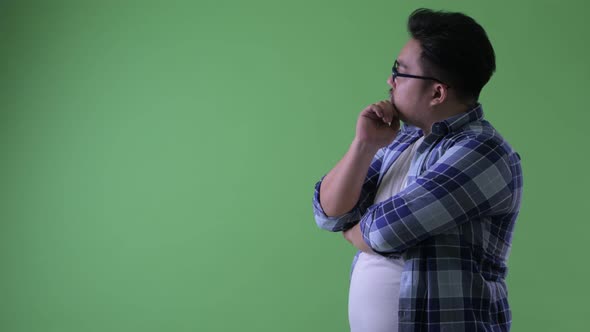 Profile View of Happy Young Overweight Asian Hipster Man Thinking