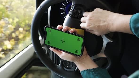 Someone using phone with green screen in car