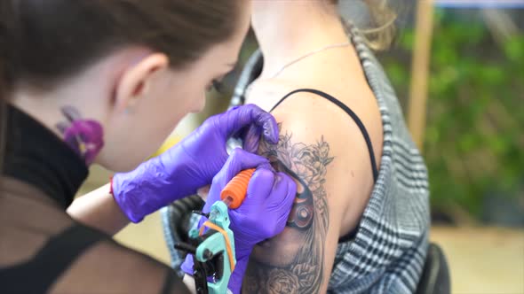 Tattoo artist tattooing an arm