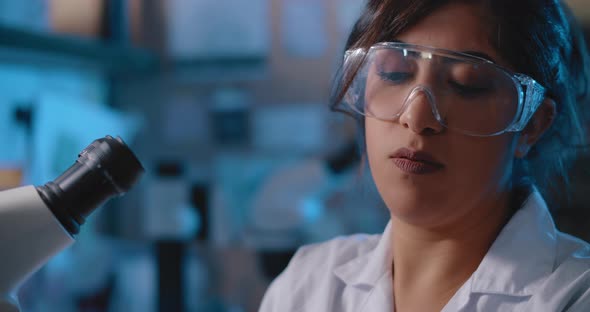 Female Research Scientist Working in a Laboratory,next To a Microscope, Close Up