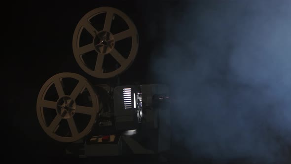 Working Projector in the Smoke. Black Background Studio