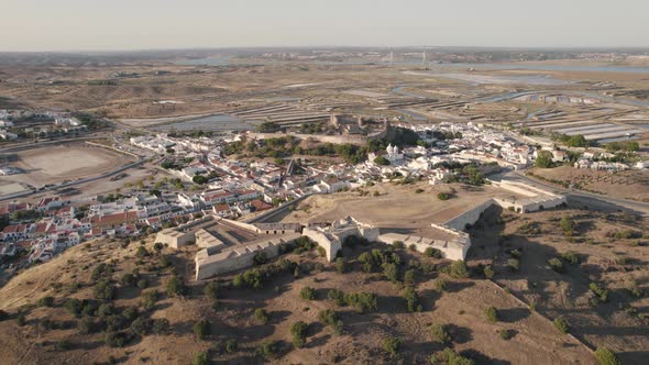 Ascending shot of historical fort and castle in Castro Marim with vast expanse of salt pans