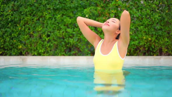 Young asian woman enjoy around outdoor swimming pool for leisure