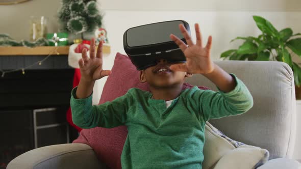 Animation of happy african american boy wearing vr headset and having fun at christmas time