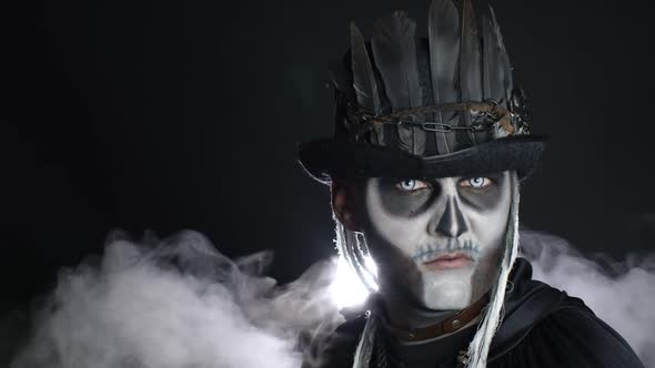 Frightening Man in Skeleton Halloween Costume Appearing From Darkness When Light Falls on Him