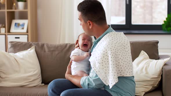 Middle Aged Father with Crying Baby at Home