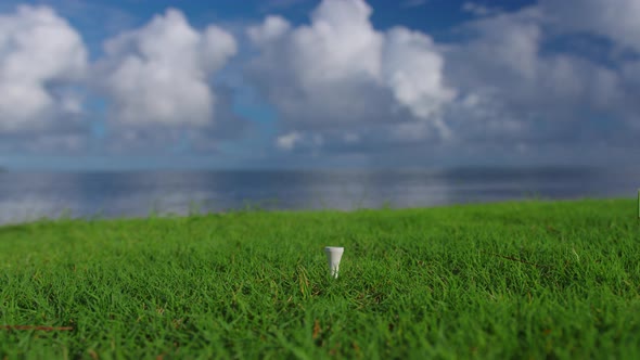 Hand in Glove Placing Golf Ball on Tee