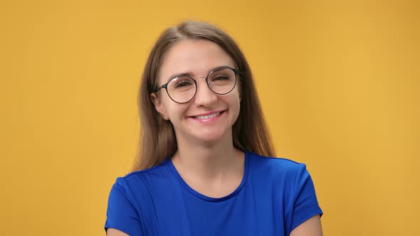 Closeup Pleasant Face Smiling Young Blonde Female in Eyeglasses Relaxing Posing Isolated on Orange