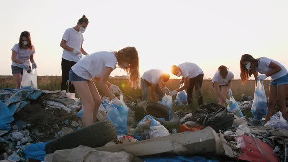 Group of Eco Volunteers Cleaning Up Area of Dump Near the Field During Sunset Gimbal Shot Slow