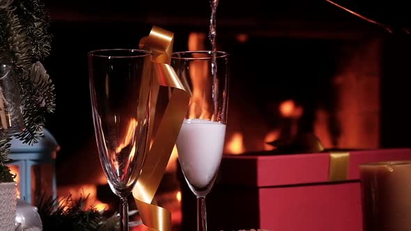 champagne glasses table in cozy room fireplace. alcoholic drink is poured glass