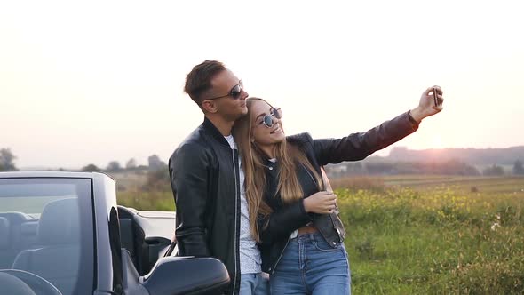 Handsome Couple in Love Taking Selfie Standing Near the Car Cabriolet