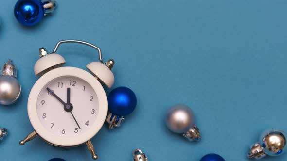White Alarm Clock on Blue Background with Christmas Balls