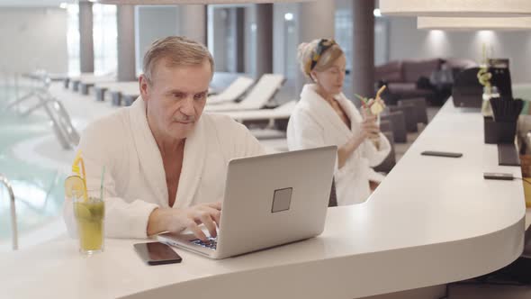 Elderly Man Working on Computer in Recreational Center