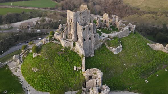 Color contrast of green hill and Corfe castle ruins in county Dorset, England. Aerial drone circling