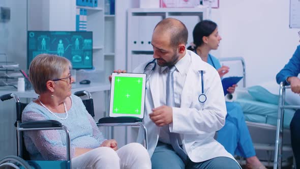 Practitioner Holding Mockup Tablet in Recovery Center for Elderly Disabled Patients