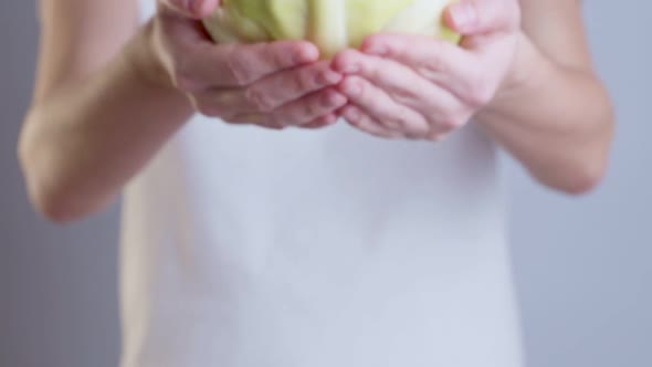 Woman Holding Showing Green Cabbage in Closeup.