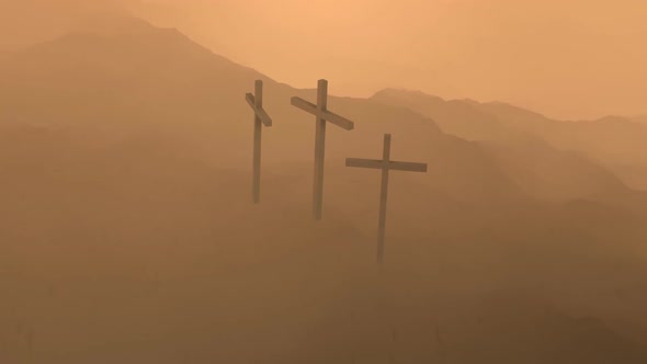 Atmospheric, dark image of three crosses silhouetted on the top of a mountain.