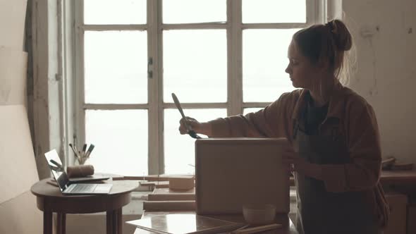 Female Joiner Applying Wood Varnish on Handmade Drawer
