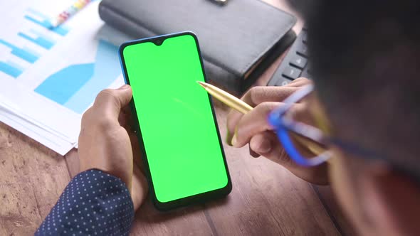 Rear View of Man Hand Using Smart Phone on Office Desk