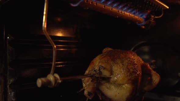 The Chicken in the Oven Roasting on a Spit.