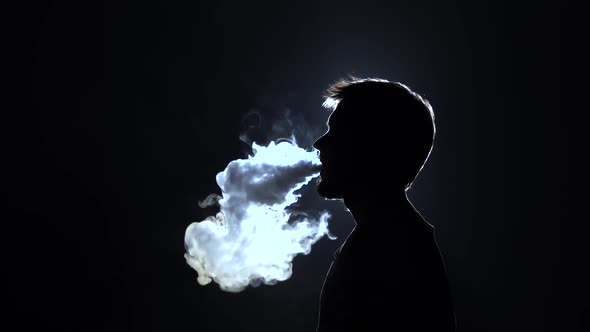 Profile View Silhouette Bearded Man Blowes Thick Smoke When Smoking Hookah on Black Background in