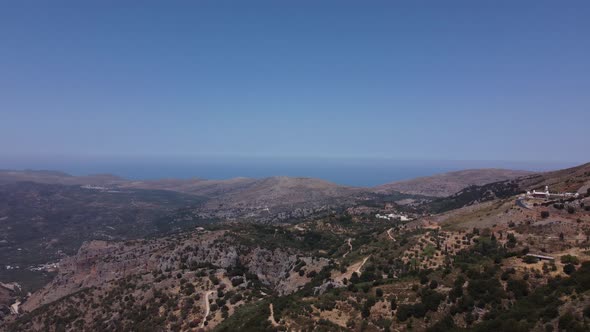 Beautiful Aerial Tracking Shot of the Tall and Majestic Mountains in Crete Greece with the Deep Blue