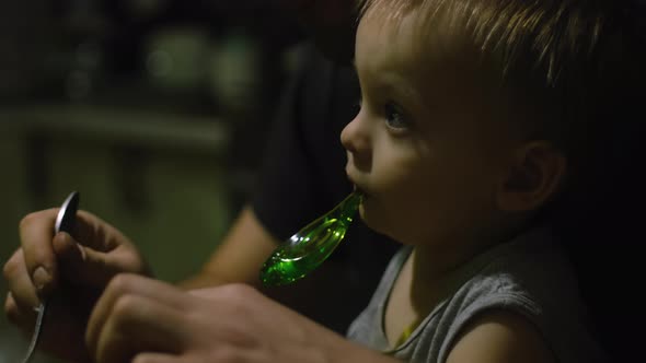 Little Son Sits on His Father's Lap During Dinner