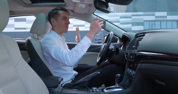 Young Businessman Having Video Chat Using Smartphone While Sitting in a Car