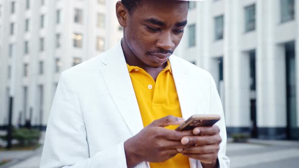 Concentrated black guy in t shirt and stylish suit with fedora hat