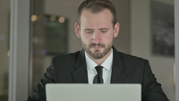 Close Up of Serious Businessman Looking at Camera at Night