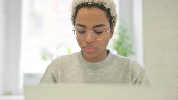 Close Up of African Woman Coughing While Using Laptop