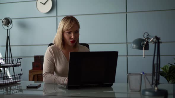 A Young Businesswoman Communicates Video Link. A Woman Speaks While Looking at a Laptop Computer