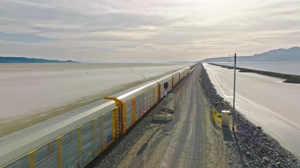 AERIAL - Sideway Shot with Train Going on tracks at Great Salt Lake Railroad
