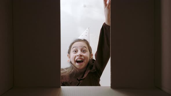 Surprised Child Opening Cardboard Box with Birthday Gift