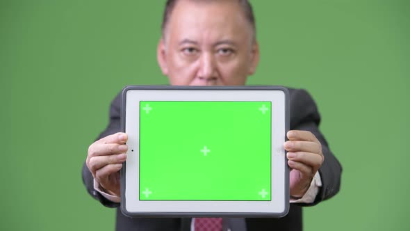 Mature Japanese Businessman Showing Digital Tablet